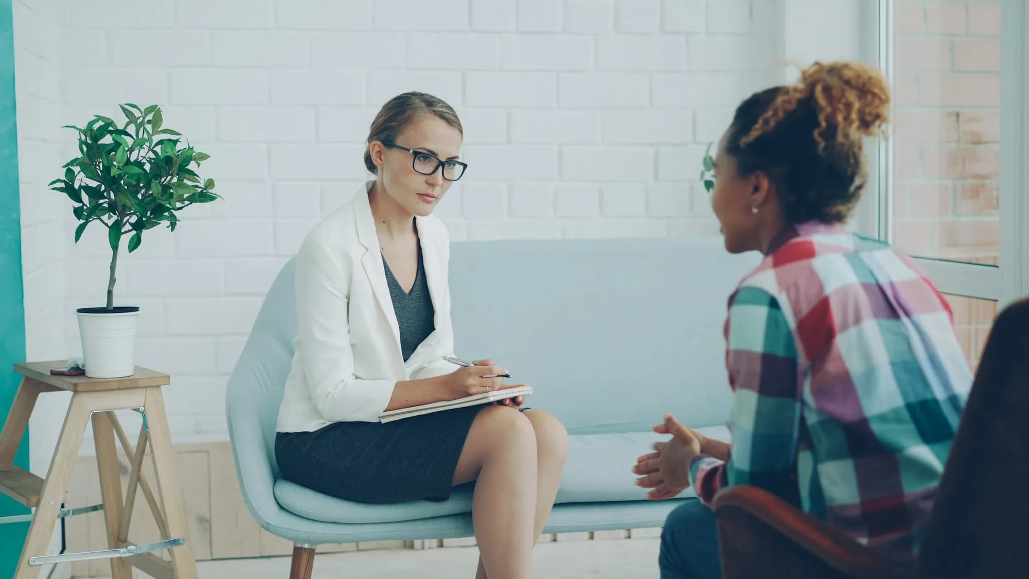 A therapist in conversation with a young woman during a counseling session